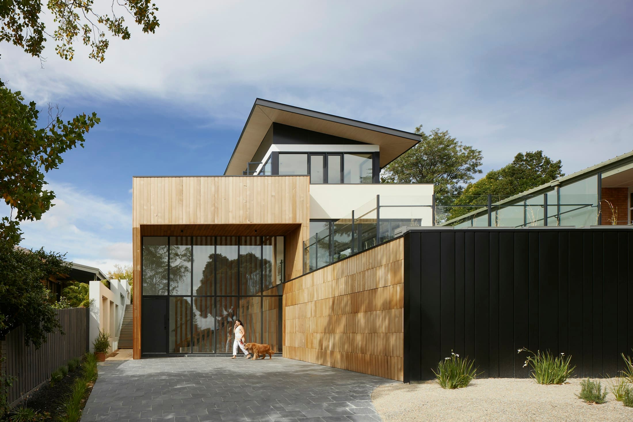 The new face to the passage — raw timber and corten from the workshop's own vocabulary.