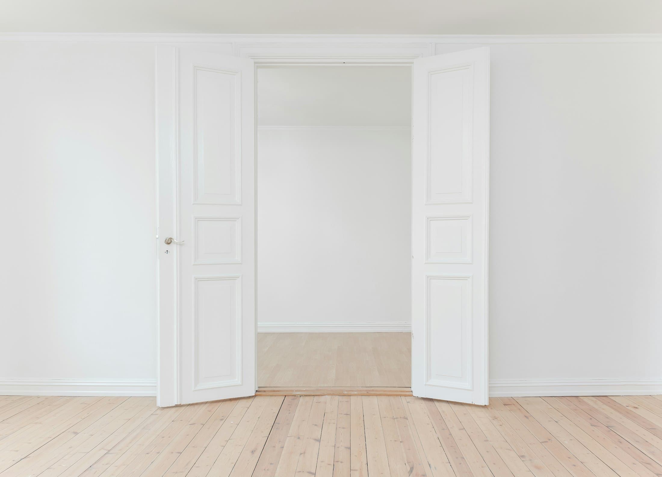 A restored gallery awaiting its first exhibition — original doors, new oak floor, nothing else added.