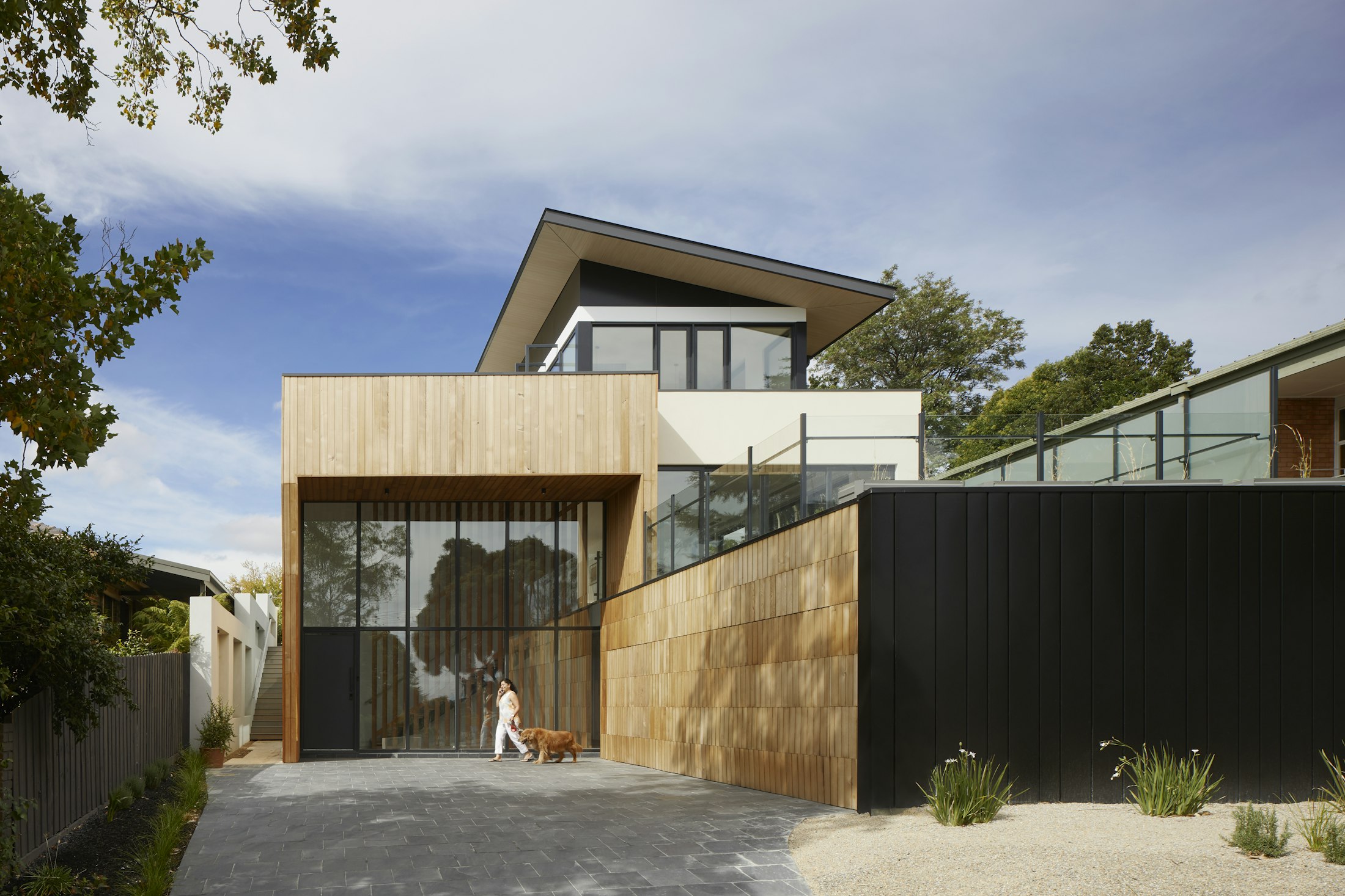 The new face to the passage — raw timber and corten from the workshop's own vocabulary.