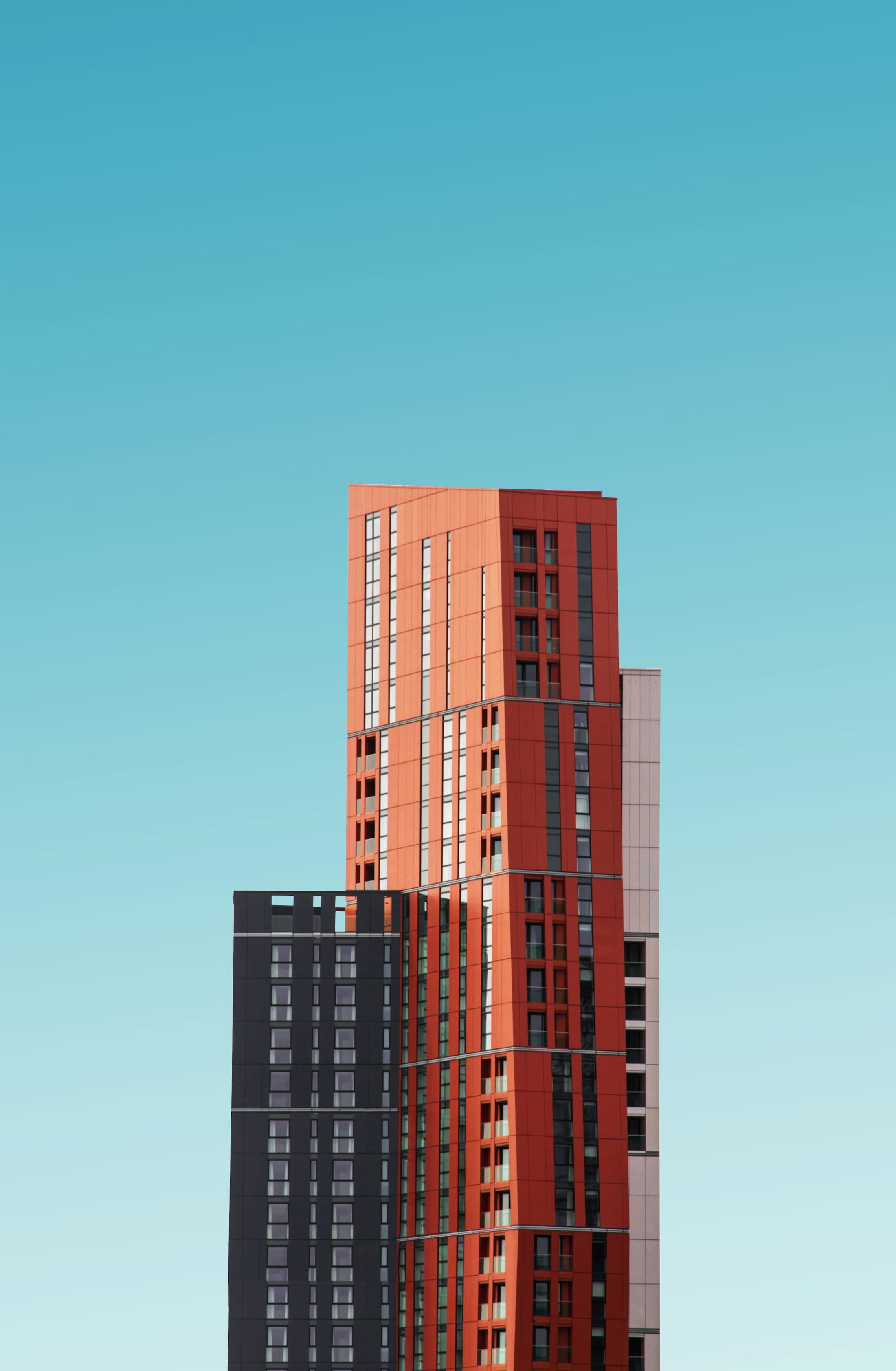 The tower against a summer sky — load-bearing brick in the red of Poblenou's industrial chimneys.